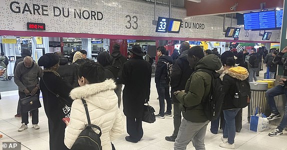 Passengers wait as Eurostar trains to London and all trains heading to northern France have been brought to a halt following the discovery of an unexploded bomb dating back to World War II near the tracks, Friday, March 7, 2025 at the Gare du Nord station in Paris. (AP Photo/Samuel Petrequin)