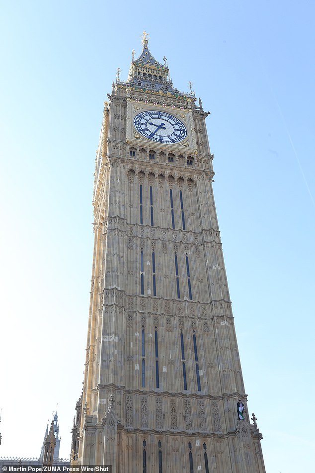 The protester pictured on the side of Big Ben today after scaling the historic structure