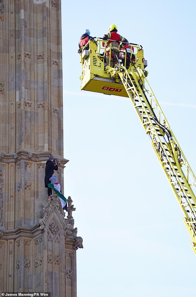 Firefighters attempting to rescue the protester from the side of Elizabeth tower this morning