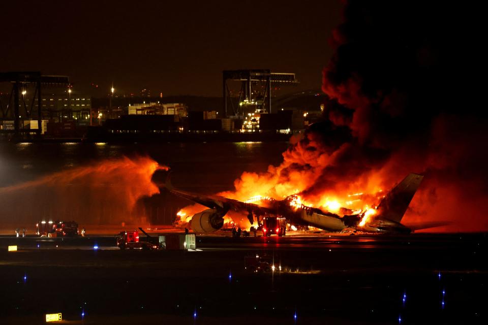 Firefighters work at Haneda International Airport after Japan Airlines' A350 airplane caught on fire, in Tokyo, Japan January 2, 2024.