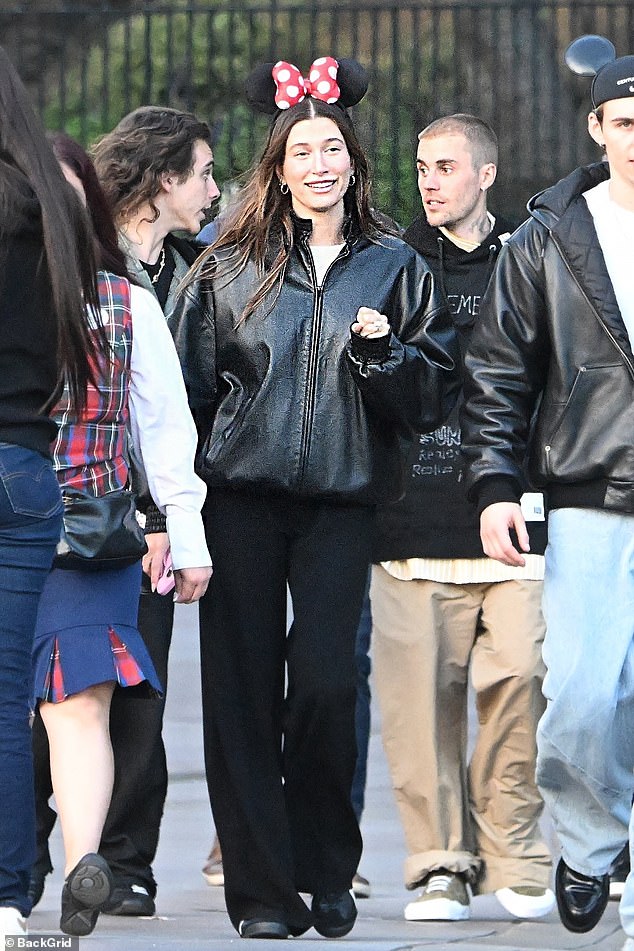 Even though Justin looked mostly stone-faced, Hailey seemed to be having a good time as they walked through the park. She beamed while wearing Minnie Mouse ears and a cool black leather jacket that complemented her husband