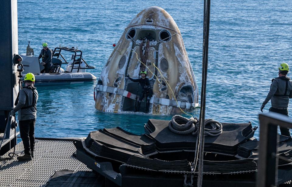 Support teams work around a SpaceX Dragon spacecraft shortly after it landed with NASA astronauts Nick Hague, Suni Williams, Butch Wilmore, and Roscosmos cosmonaut Aleksandr Gorbunov.