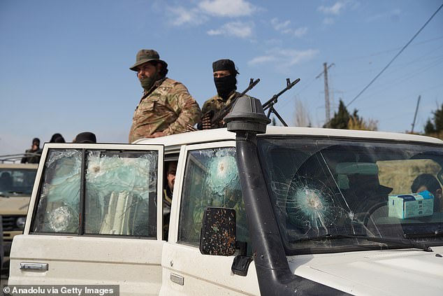 Soldiers are seen in a vehicle with damaged windows as authorities extended the curfew in the cities of Latakia and Tartus in northwest Syria on Friday and launched large-scale security sweeps in urban centers, villages, and surrounding mountains to track down remnants of the deposed Bashar al-Assad regime on March 07, 2025 in Latakia, Syria