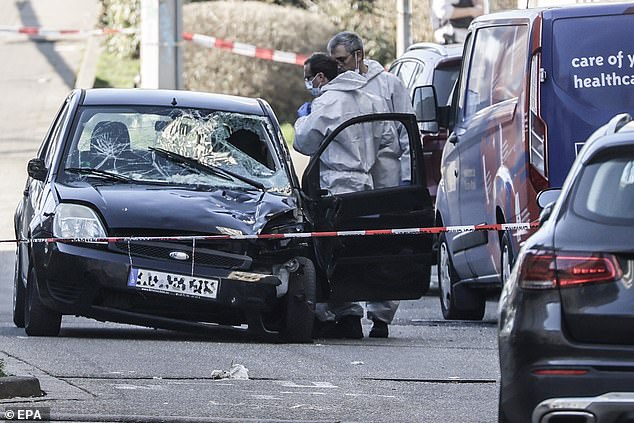 Police investigators check a damaged car at the scene after a vehicle was driven to pedestrians in Mannheim