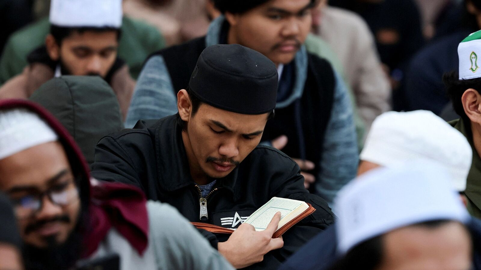 A Muslim reads the holy book of Koran as Muslims gather for a collective Iftar meal organised by Al-Azhar mosque for foreign students during the holy month of Ramadan. REUTERS/Mohamed Abd El Ghany