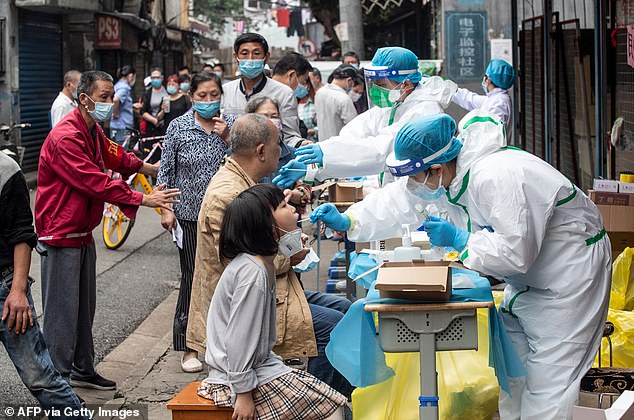 Medical workers take swab samples from residents to be tested for the COVID-19 coronavirus, in a street in Wuhan in China's central Hubei province on May 15, 2020