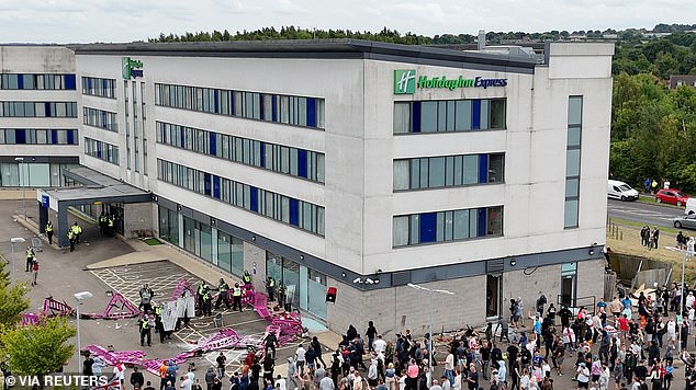 Anger led to attacks on hotels housing asylum seekers in the wake of the Southport killings (pictured, a crowd outside the Holiday Inn Express in Rotherham last August)