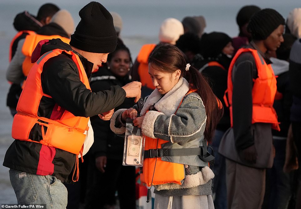 A couple are seen placing their phones into waterproof bags ahead of entering the water to board a small dinghy