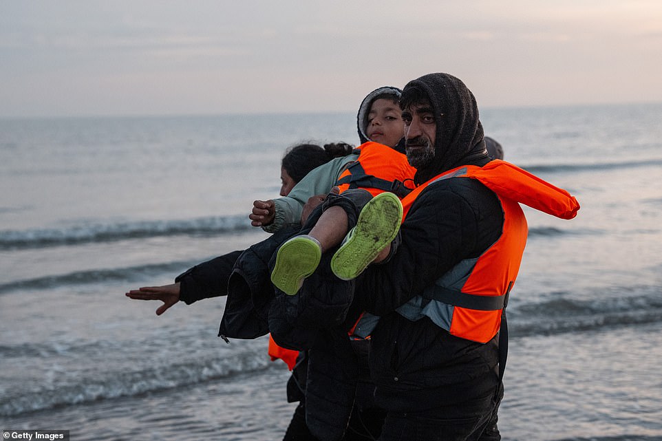 A young boy and his family prepare to board a boat in a bid to reach the UK from France