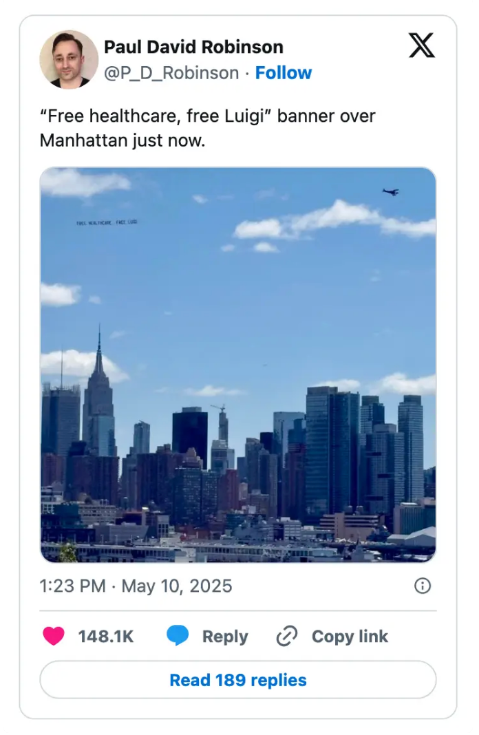 Banner over Manhattan skyline reads "Free healthcare, free Luigi."