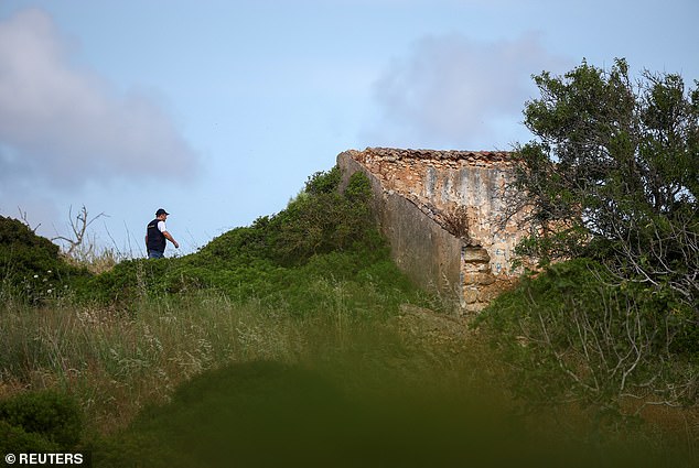 A criminal police investigator walks near ruins during the renewed search for evidence in the Algarve