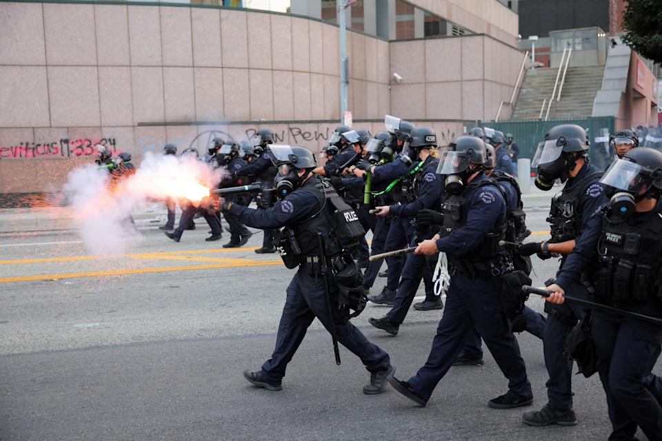 Daniel Cole/Reuters - PHOTO: A police officer uses stun grenades as they approach the protesters gathered around the Los Angeles Federal Building following multiple detentions by Immigration and Customs Enforcement (ICE), in downtown Los Angeles, June 6, 2025.
