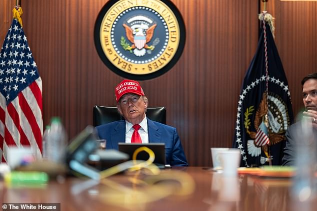 President Donald Trump, wearing his red Make America Great Again ballcap, is photographed in the White House Situation Room Thursday evening. Secretary of State Marco Rubio (right) was at his side
