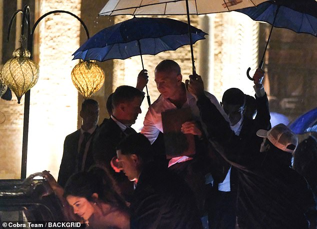 Bezos, 61, was seen following closely behind Lauren with an umbrella over his head