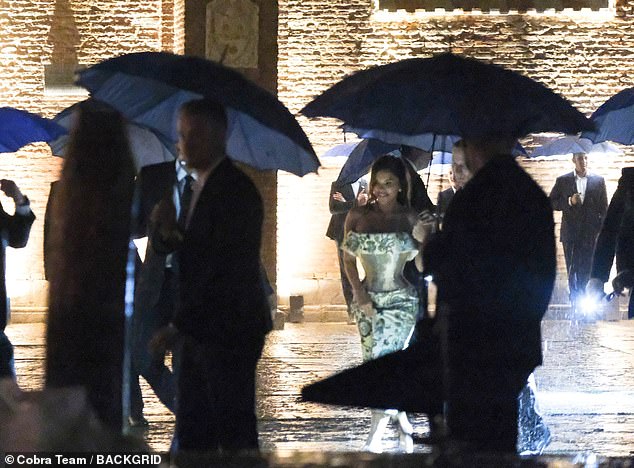 She held up her dress so that the hem wouldn't become soaked by the rain as she walked