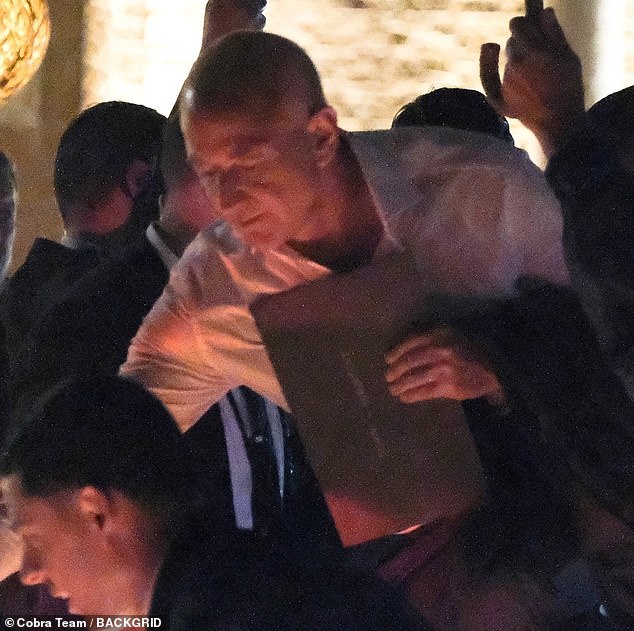 The billionaire carried what appeared to be a booklet or large envelope in one hand