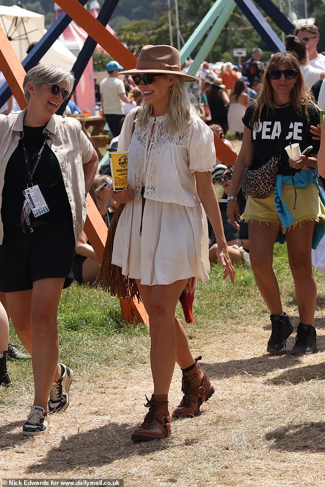 After disembarking the helicopter, Holly wasted no time kickstarting the three-day spectacular in Somerset, as she strolled around the grounds with a friend