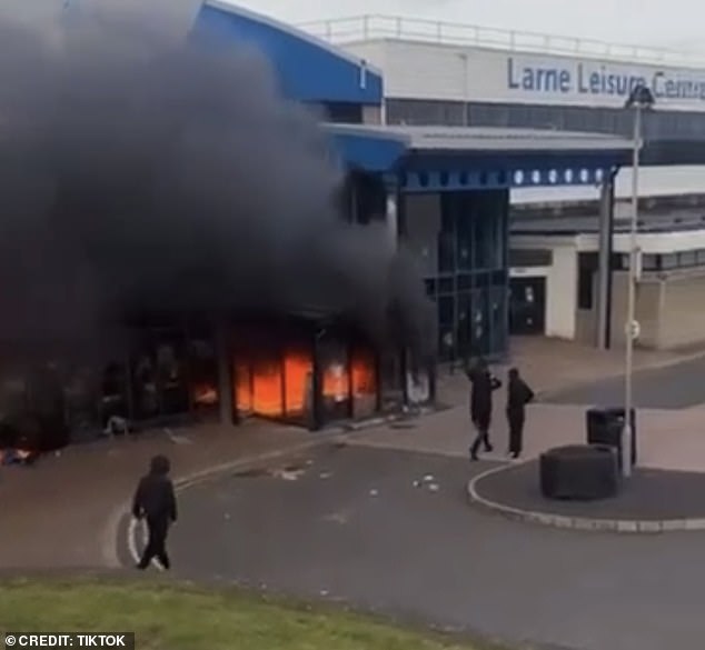 Distressing footage taken outside Larne Leisure Centre on Wednesday night shows a group of hooded thugs torching the building, which is understood to have held Romanian immigrants
