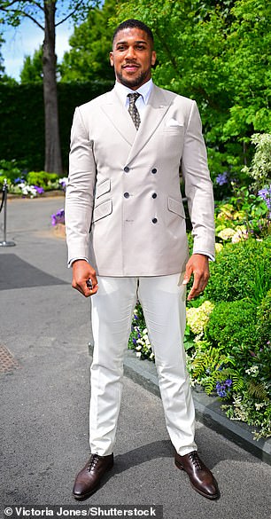 Anthony Joshua kept his buff physique under wraps in a perfectly tailored cream suit