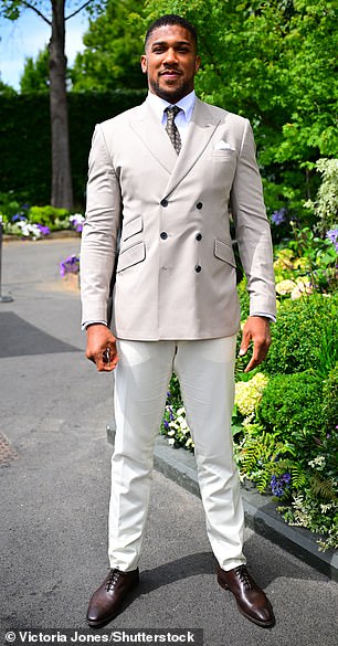 Anthony Joshua kept his buff physique under wraps in a perfectly tailored cream suit