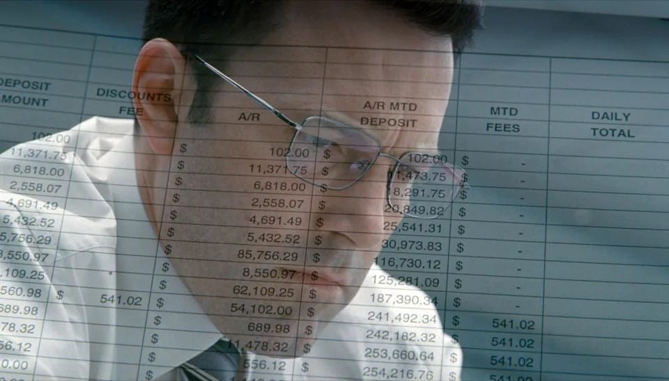 Ben Affleck with an overlay of a sheet featuring dollar amounts in "The Accountant."