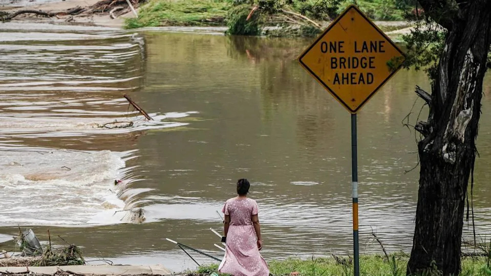 Woman looks at flooded road