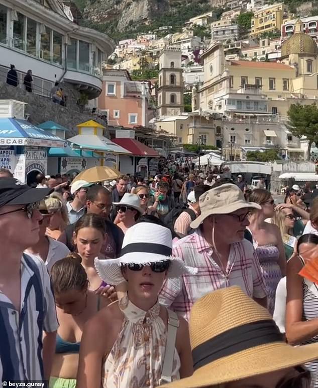 A tourist in Portofino, a small coastal town on the Italian Riviera in Liguria, revealed how even areas which are meant to be quiet have been swarmed by holiday makers. Pictured: A crowd in Positano, Italy