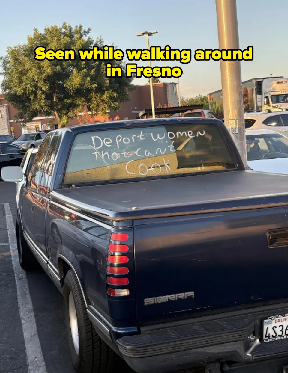 Back of a parked pickup truck with the words "Deport women that can't cook" written on the rear window. Seen in Fresno