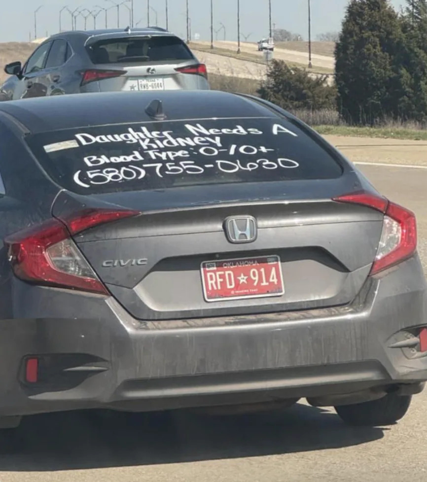 Car with message on rear window: "Daughter needs a kidney! Blood type: O-/O+"