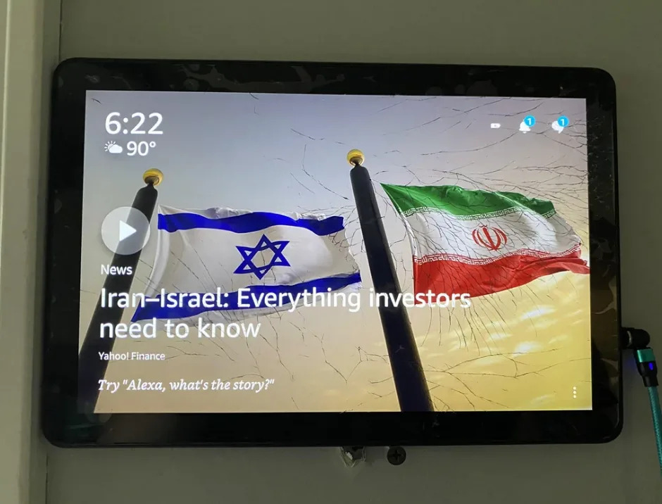 Alexa device screen showing Israeli and Iranian flags and the headline: "Iran-Israel: Everything investors need to know" from Yahoo Finance