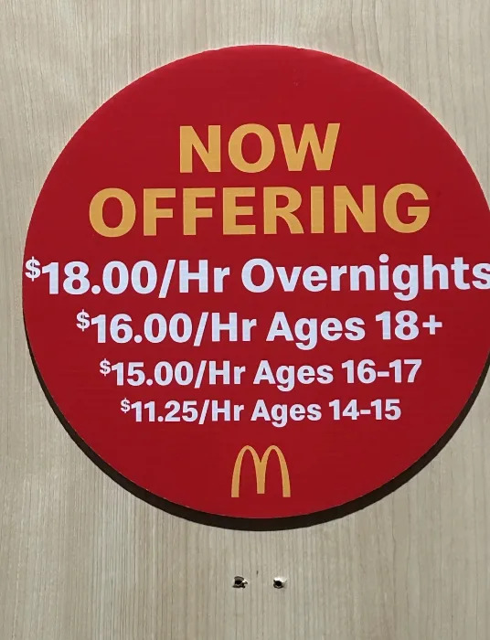 Sign advertising job openings at McDonald's with hourly wages: $18 for overnights, $16 for 18+, $15 for ages 16-17, and $11.25 for ages 14-15
