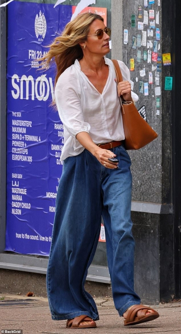 The stunner shielded her eyes behind gold rimmed aviator shades and accessorised with tan sandals and a matching handbag