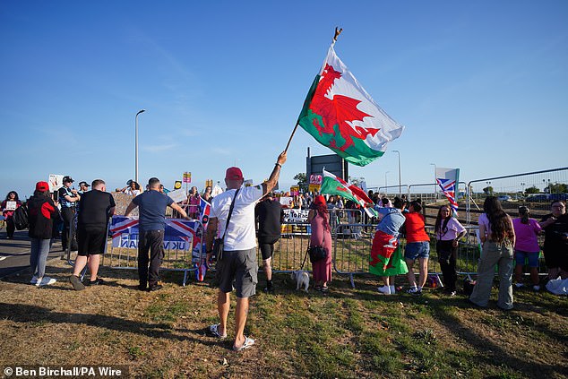 People take part in a counter protest to the Stand Up To Racism rally outside the Holiday Inn at Cardiff Airport