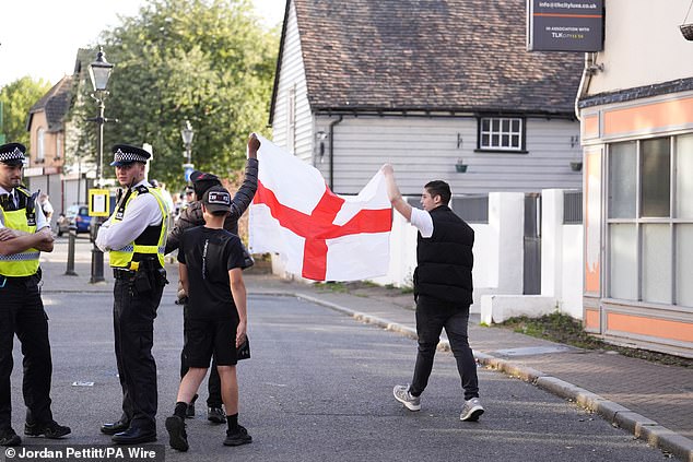 People holding a St George's flag outside the TLK Apartments and Hotel in Orpington