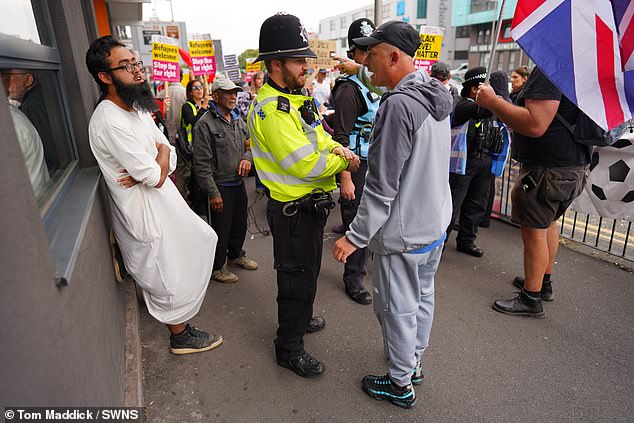 An anti-migrant protester faces off with a people taking part in a Stand Up To Racism rally outside Highcross House Apart Hotel in Leicester