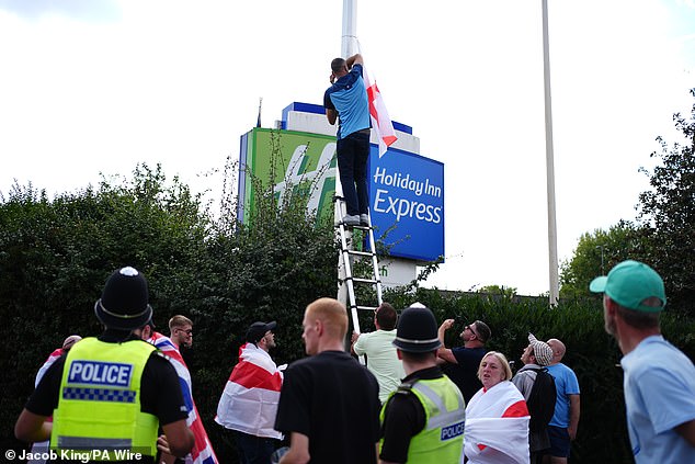A protestor in Birmingham was seen putting up a St George's Cross flag outside of the Castle Bromwich Holiday Inn