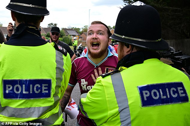 At least 15 people were reportedly arrested in Bristol, Liverpool and Horley on Saturday, The Times reported. Pictured: a demonstrator clashes with police officers outside the Sheraton Four Points Hotel in Horley