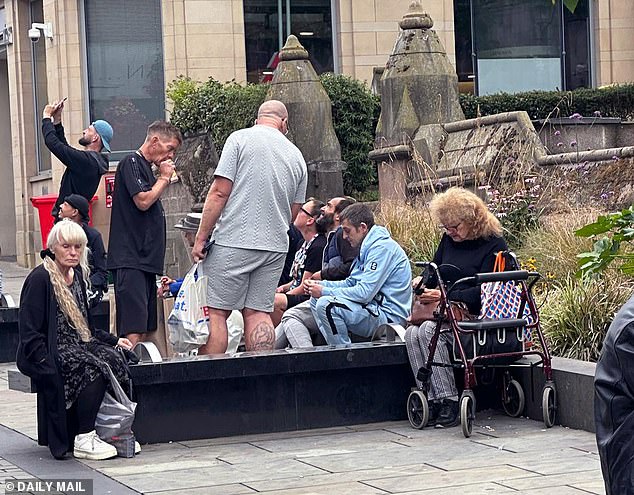 A group of females and males were seen at a seated concrete area outside NatWest bank drinking and seemingly doing drugs when the Daily Mail visited