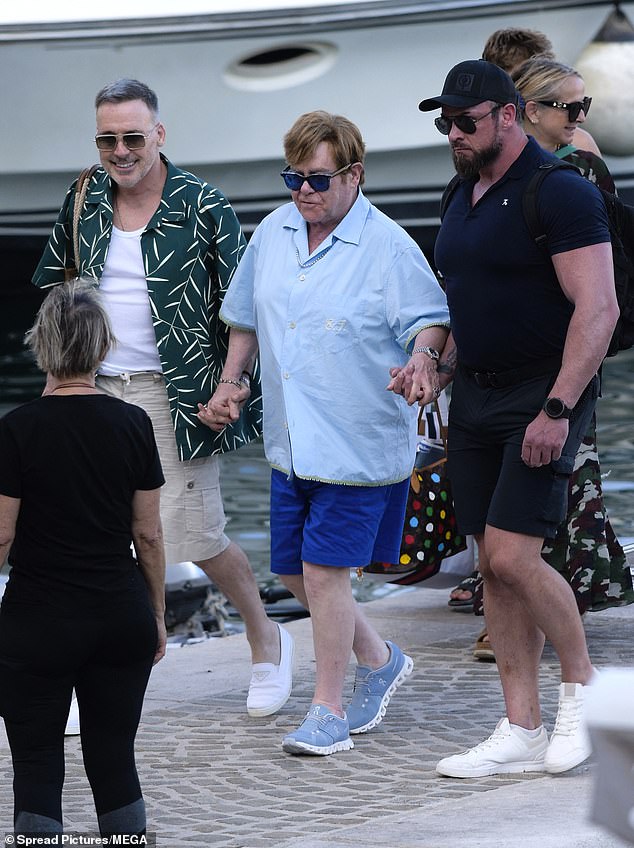 The musician was supported by his spouse David and another member of his team as he exited the yacht