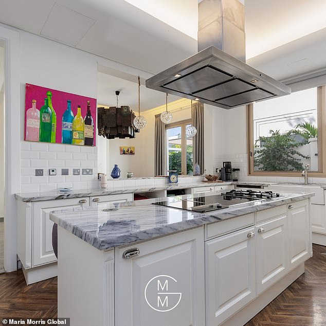 The property's 'state of the art' kitchen features high-end Miele appliances as well as a sleek centre island with a grey counter tops