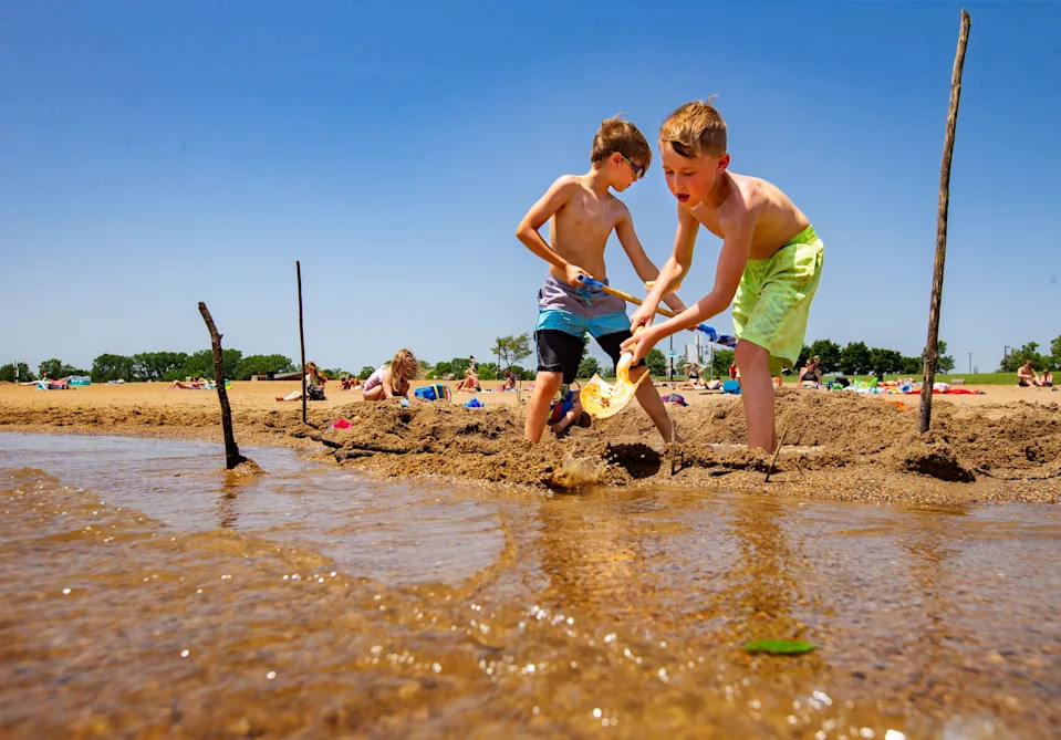 Korbin Daniels, left, and Jax Carper, both 8, dig in the beach of Blue Heron Lake at Raccoon River Park in West Des Moines.