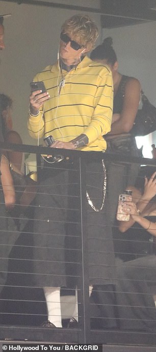Meanwhile MGK, Colson Baker, cut a cool figure with shades and headphones