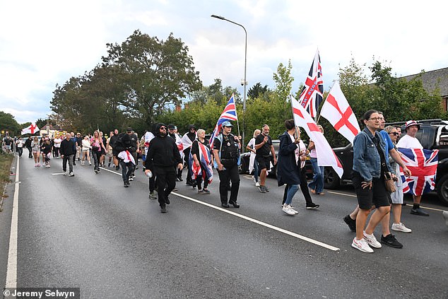 Protesters march towards the Bell Hotel this evening, waving England flags and Union Jacks on Friday