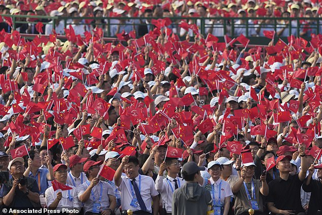 Spectators react ahead of a military parade to commemorate the 80th anniversary of Japan's World War II surrender held in front of Tiananmen Gate in Beijing
