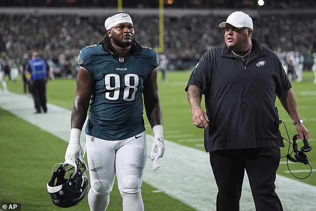 Carter walks off the field with Eagles' head of security Dom DiSandro after being ejected