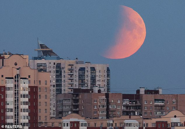 Partial lunar eclipse as the moon raises over residential buildings in Saint Petersburg, Russia
