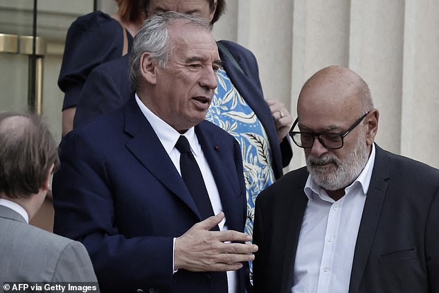 France's Prime Minister Francois Bayrou (L) leaves the National Assembly after the result of a confidence vote over the government's austerity budget,