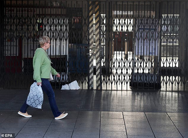 A woman walks past a closed London Underground station today as the strike continues