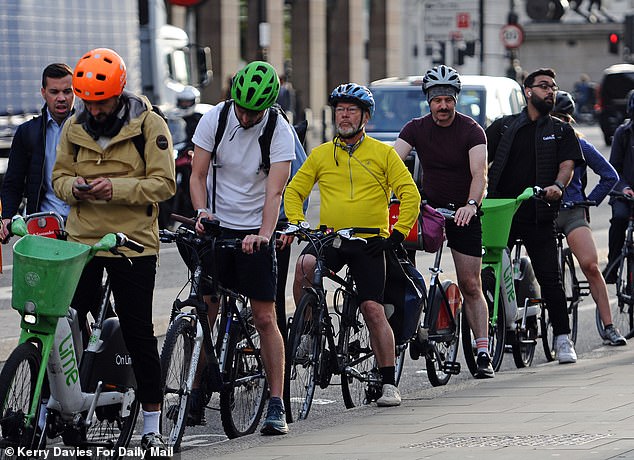 Cyclists make their way to work in London yesterday during the ongoing Underground strike