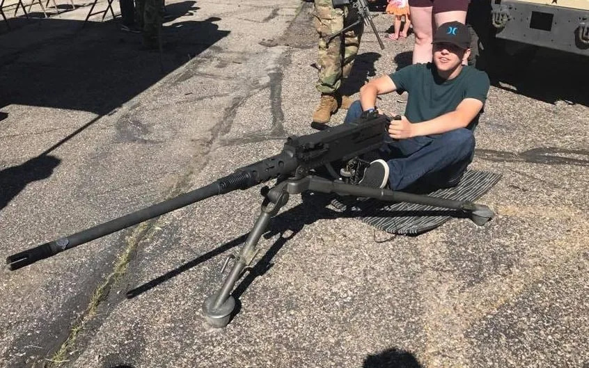 Robinson poses with an M2 Browning .50 calibre machine gun